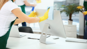 anitor wiping down office computer in a clean Chicago workspace