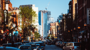 Street view of Wicker Park with traffic and shops, city skyline in background