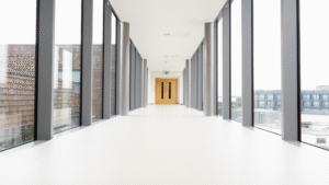 unlit hospital corridor with large windows and clean floors