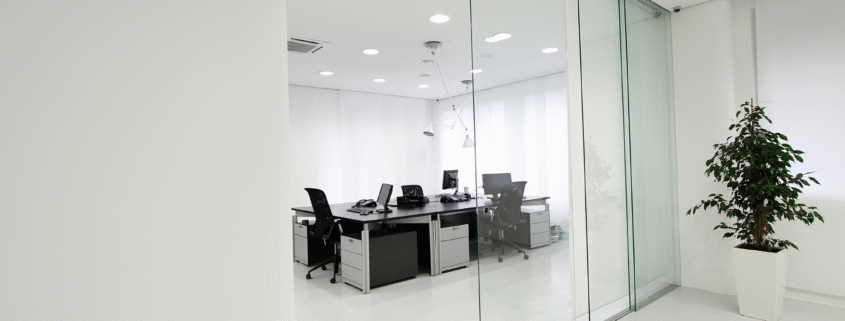 Pristine office space with glass partitions and clean white floors