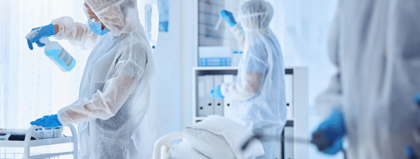 Professional hospital cleaning crew disinfecting a patient room
