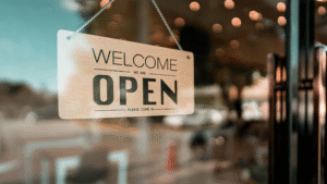 Close-up of a clean storefront window with a “Welcome We Are Open” sign.