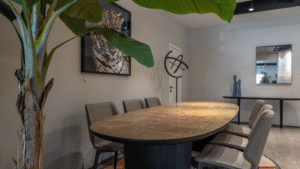  Modern conference room with wooden table, chairs, and clean flooring in a commercial setting.