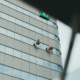 Window cleaning team working on a tall commercial glass building