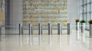 Luxury office lobby with marble flooring, designer stone wall, and turnstile entry.