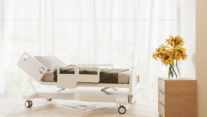 Bright patient room with hospital bed and flowers near the window.