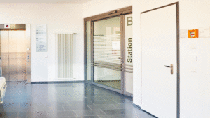 Clean hospital corridor with elevator and station entrance.