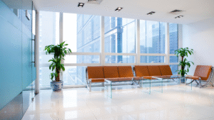 Modern waiting room with brown chairs and large glass windows.