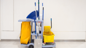 Professional janitorial cleaning cart with mop, broom, and sanitation supplies.