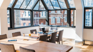 Bright conference room with large windows, clean table, and organized chairs.