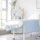 Fresh patient room with light blue blanket and greenery.