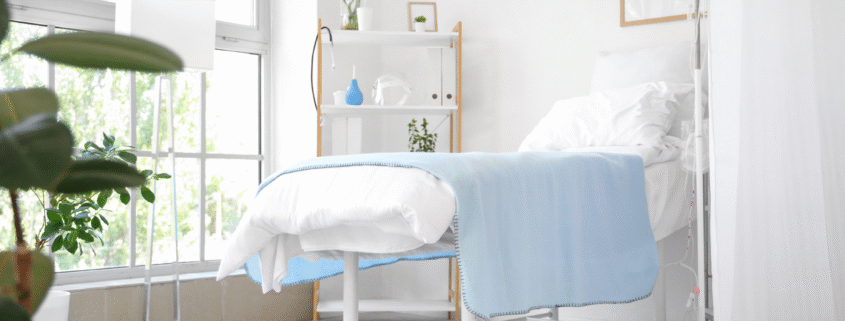 Fresh patient room with light blue blanket and greenery.