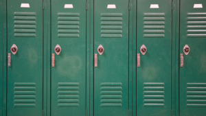 Row of clean green school lockers in a hallway.