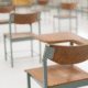 Empty classroom with old wooden desks and chairs.