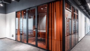 Office corridor with enclosed glass meeting rooms and orange curtains