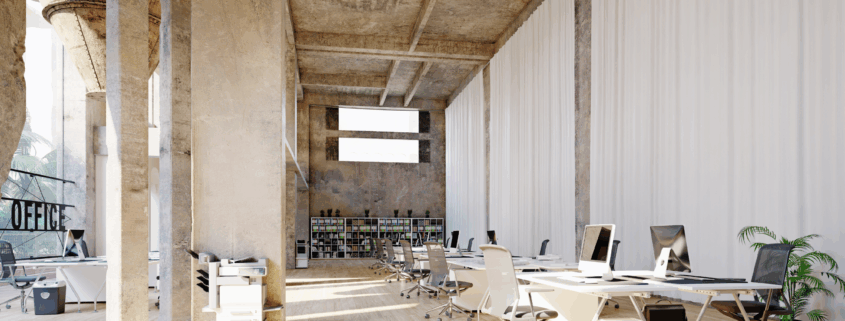 Open-concept office space with white desks and floor-to-ceiling curtains