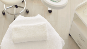 Rolled white towel on sanitized medical bed, ready for patient care