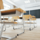 Close-up of clean classroom desks arranged neatly with bright natural lighting.