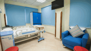 Hospital patient room with bed, chair, and medical equipment after terminal cleaning