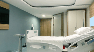 Private hospital recovery room with clean bedding and seating for patient comfort