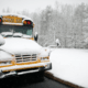 Snow-covered school bus parked outside during winter weather