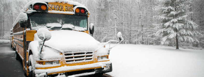 Snow-covered school bus parked outside during winter weather