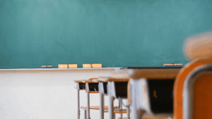 Clean classroom with desks and chalkboard ready for students