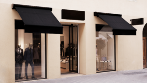 Luxury retail storefront with large glass windows and mannequins in a clean urban setting.