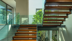Modern staircase with wood steps and glass railings inside commercial building
