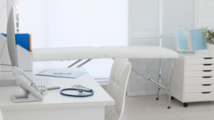 Modern doctor office with exam table, desk, and medical equipment