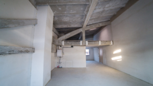 Raw concrete interior with staircase and unfinished walls after construction