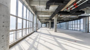 Industrial interior with exposed ductwork and sunlight highlighting dust on floors