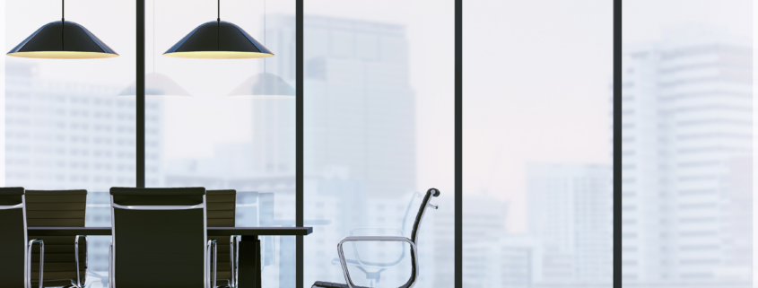 Modern office meeting room with glass walls, chairs, and city view