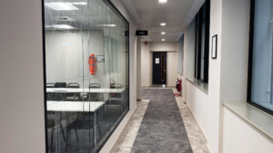 Office hallway with glass walls and clean carpet maintained by Professional Office Cleaning in Chicago