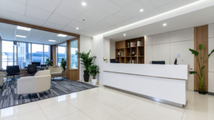 Office reception area with seating, front desk, and clean floors