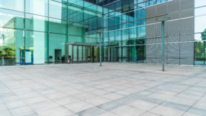 large commercial building entrance with glass facade and clean exterior floors