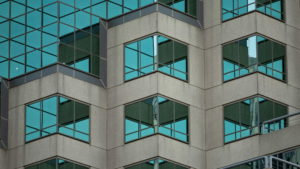 Modern office building with reflective glass windows showing dirt and buildup