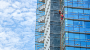 Window cleaners using rope access on tall commercial building