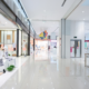 Modern shopping mall interior with clean walkways and organized retail storefronts.