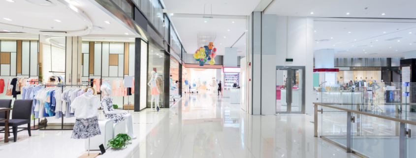 Modern shopping mall interior with clean walkways and organized retail storefronts.