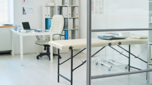 Medical exam room with treatment table, organized workspace, and clean surrounding surfaces.