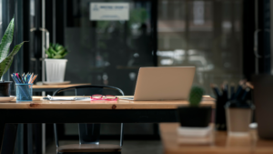 Clean office desk with laptop, organized workspace ready for employees