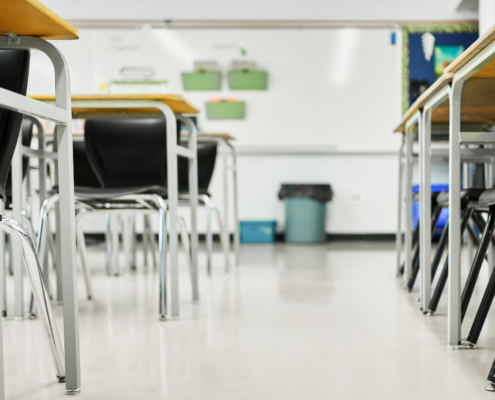 Clean classroom with organized desks and chairs prepared for students before the school day begins.