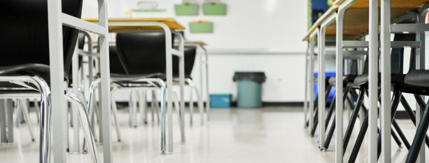 Clean classroom with organized desks and chairs prepared for students before the school day begins.