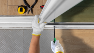Technician repairing or installing a commercial door using tools and measuring equipment.