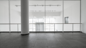 Large commercial building interior with open floor space and floor-to-ceiling windows after construction.