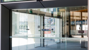 Modern commercial entrance with glass panels, clean flooring, and well-maintained common areas.