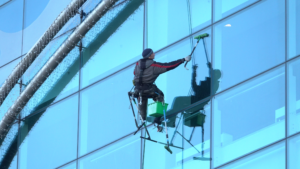 High-rise window cleaner maintaining exterior commercial glass panels.