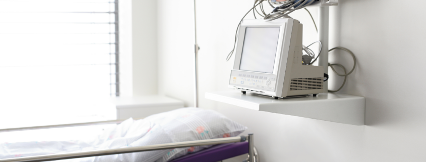 Hospital patient room with monitoring equipment and medical devices near a hospital bed