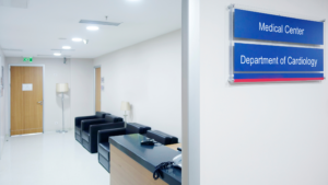 Hospital corridor with patient room entrances and waiting chairs